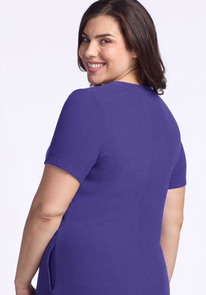 Woman with dark hair smiles over her shoulder in the Woolx Harlowe Ribbed Dress - Berry Indigo against a white background.