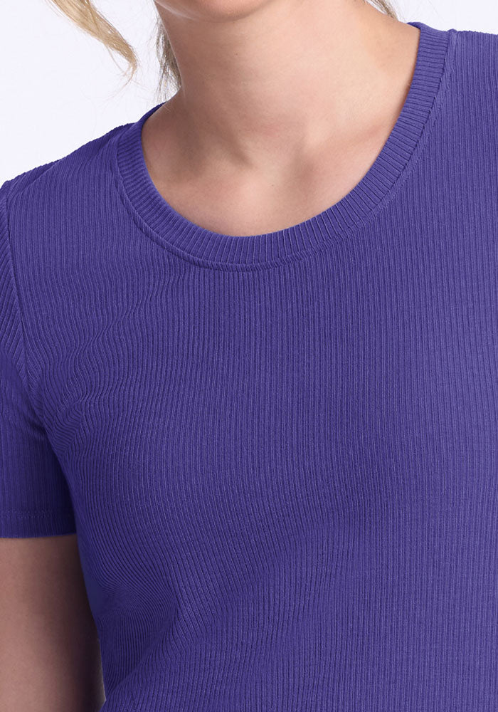 A person in the Woolx Harlowe Ribbed Dress in Berry Indigo; short-sleeve, moisture-wicking comfort, face partly visible.
