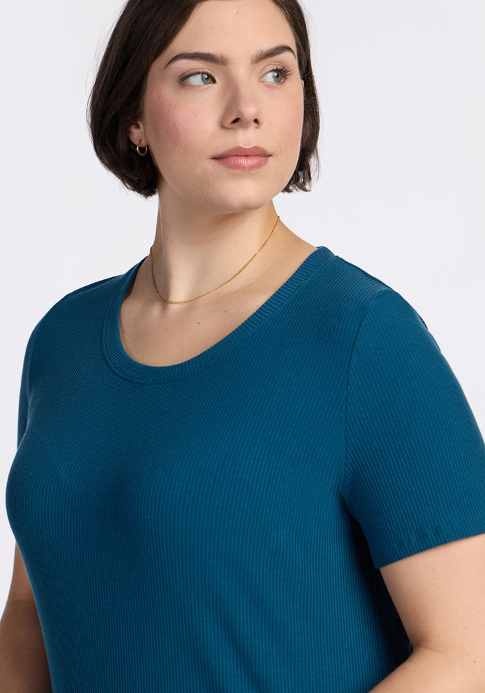 Woman with short brown hair in Woolx's Harlowe Ribbed Dress in Moroccan Blue, perfect for travel.