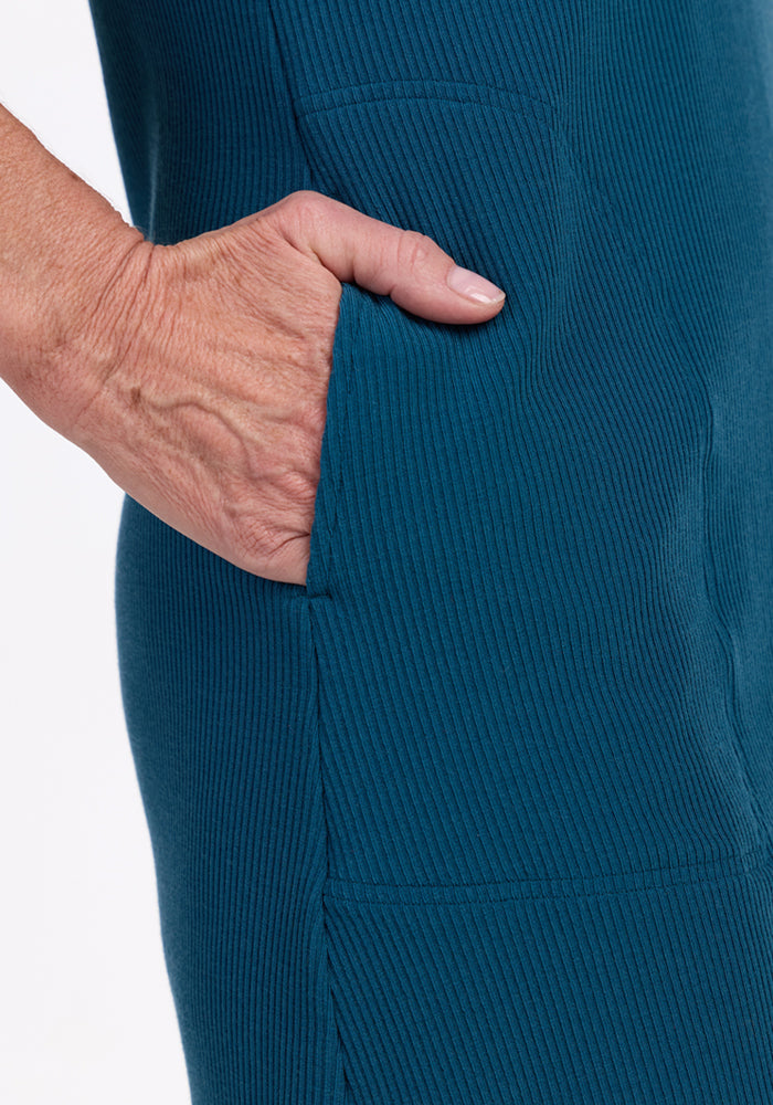 A close-up of a hand in the pocket of the Woolx Harlowe Ribbed Dress in Moroccan Blue.
