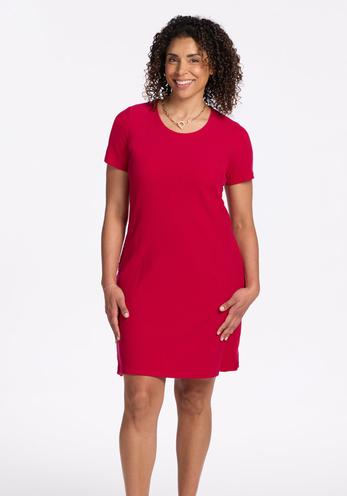 Woman with curly hair smiles in the Woolx Harlowe Ribbed Dress in Poppy Spark, against a white background.
