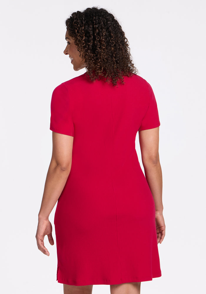 A woman with curly hair wears the Woolx Harlowe Ribbed Dress in Poppy Spark, shown from the back.