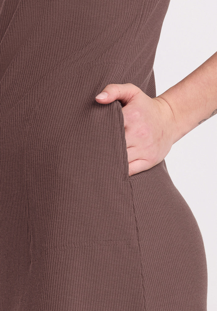Close-up of a hand in the pocket of the Woolx Harlowe Ribbed Dress - Peppercorn against a light background.