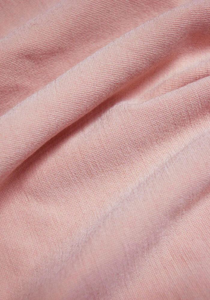 Close-up of the soft, light pink fabric of the Woolx Hayden Bra in Rosewater, with visible texture and gentle folds that evoke the seamless comfort of your favorite bra.