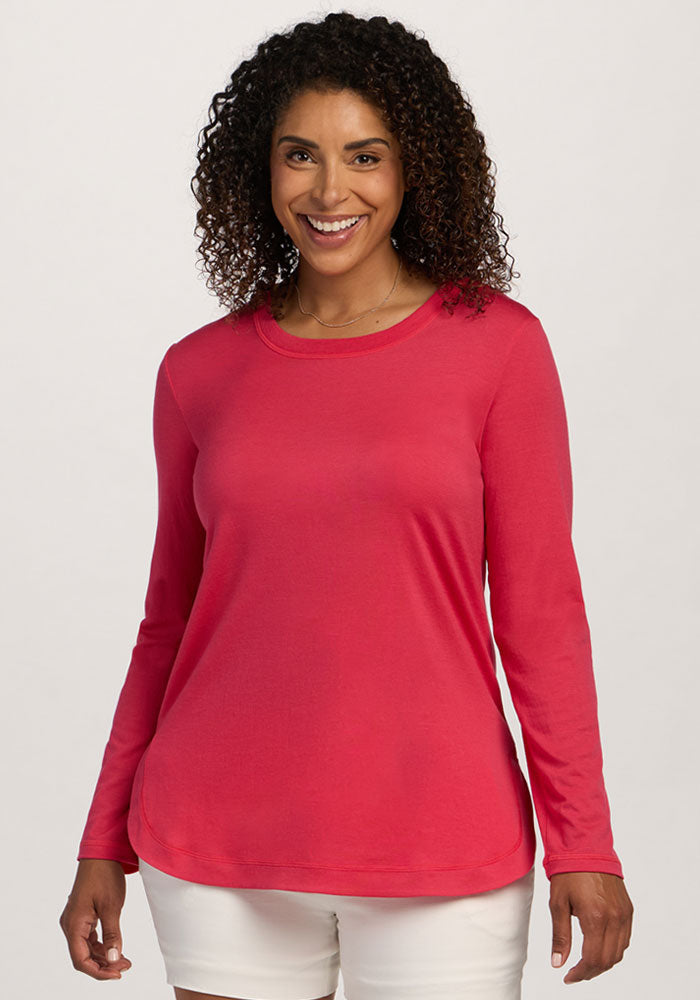 Smiling woman in a Woolx Hazel Tunic - Berry Ice Pop and white shorts, standing before a plain light background. | Kisha is 5'8", wearing a size M