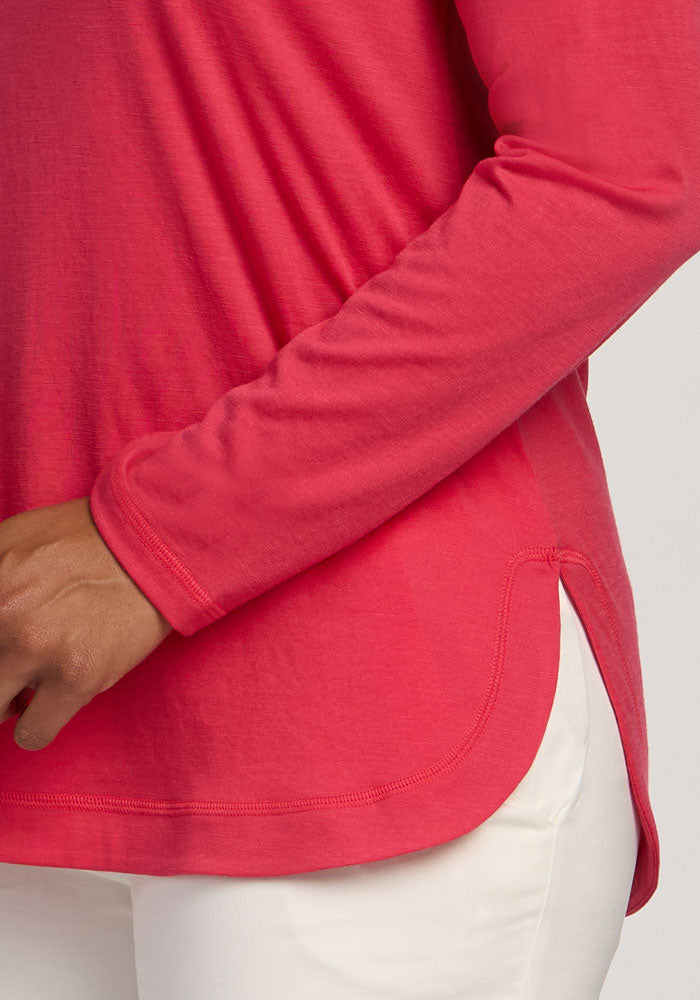 A person wears the Woolx Hazel Tunic in Berry Ice Pop with white pants, hand resting near their waist.