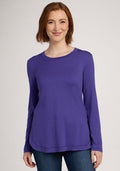 Smiling woman in a Woolx Hazel Tunic - Berry Indigo and blue jeans stands against a neutral background. | Shea is 5’9”, wearing a size S