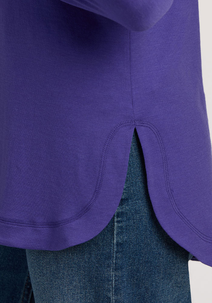 Close-up of the Woolx Hazel Tunic - Berry Indigo, a lightweight merino wool top, styled with blue denim jeans.