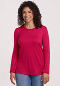 Smiling person in the Woolx Hazel Tunic • Final Sale - Poppy Spark and blue jeans, standing against a plain background.