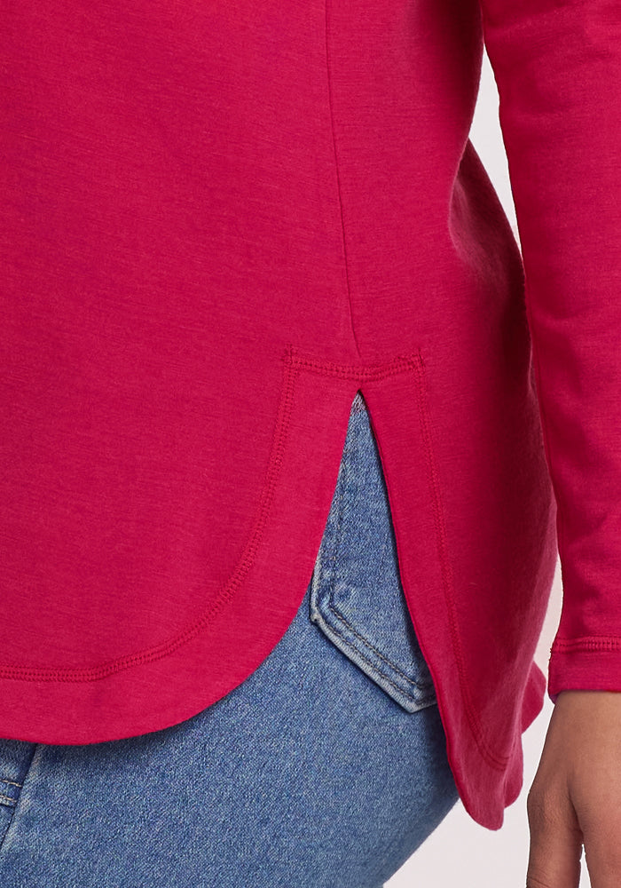 Close-up of a person in Woolx Hazel Tunic • Final Sale - Poppy Spark with a side slit, paired with blue jeans.