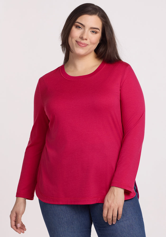 Smiling woman with long dark hair in a Woolx Hazel Tunic • Final Sale - Poppy Spark and blue jeans.