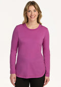 Woman smiling in a Woolx Hazel Tunic in Purple Wine and black pants, standing against a plain white background.