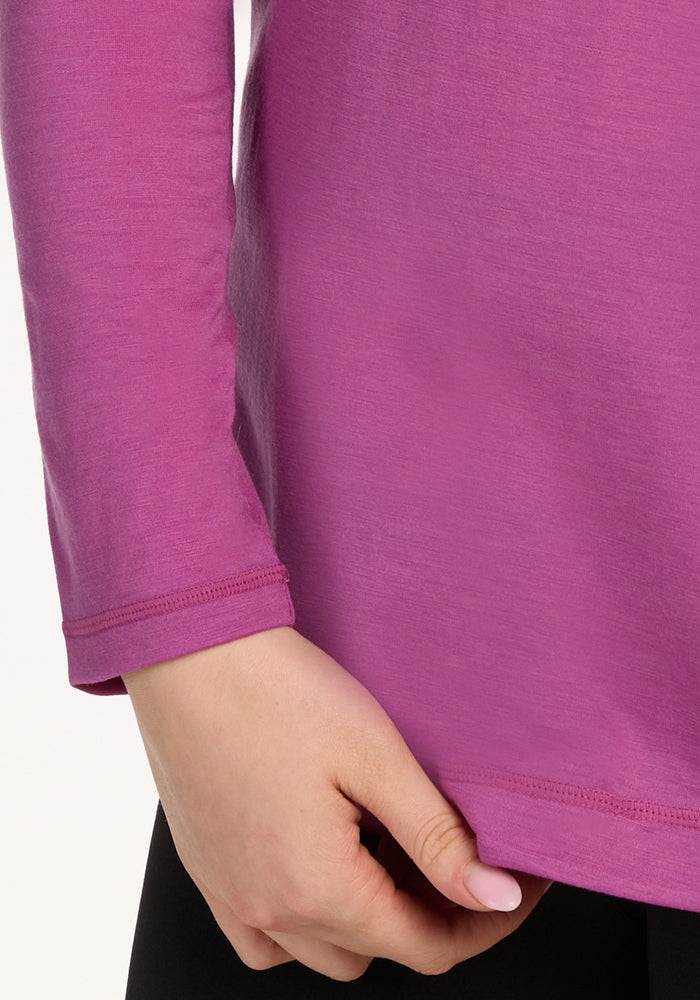 A person in a Woolx Hazel Tunic • Final Sale - Purple Wine holds the hem, showing only their torso and hand.