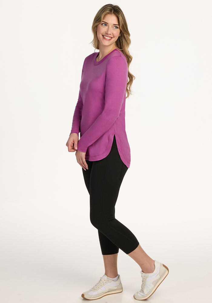 Woman in Woolx Hazel Tunic in Purple Wine, smiling and posing against a white background.