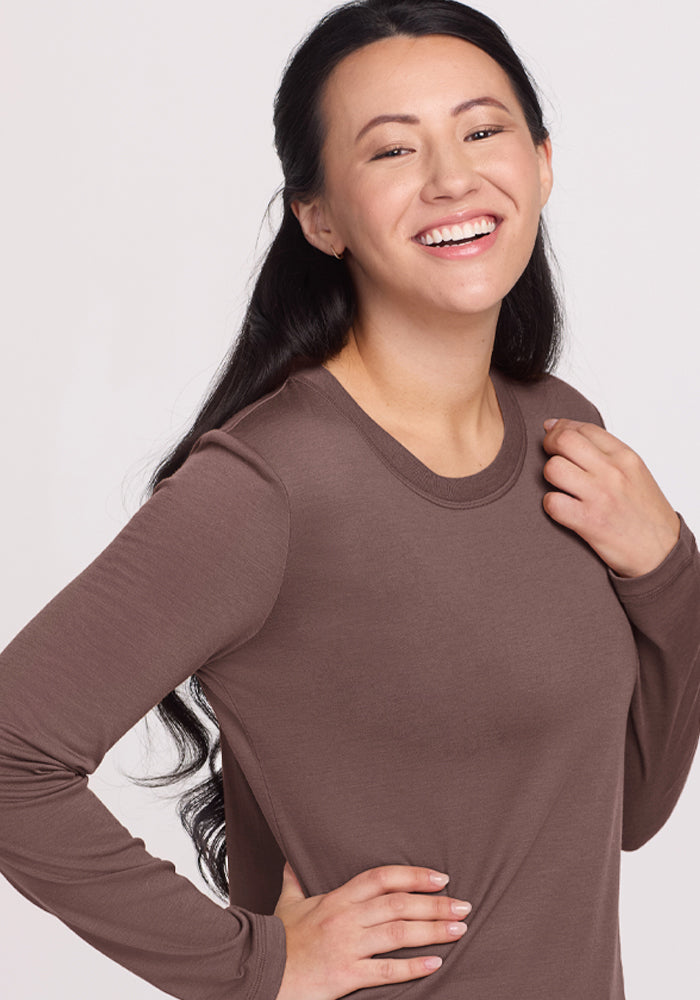 Smiling woman with long dark hair wears the Woolx Hazel Tunic - Peppercorn, hand on hip against a light background.
