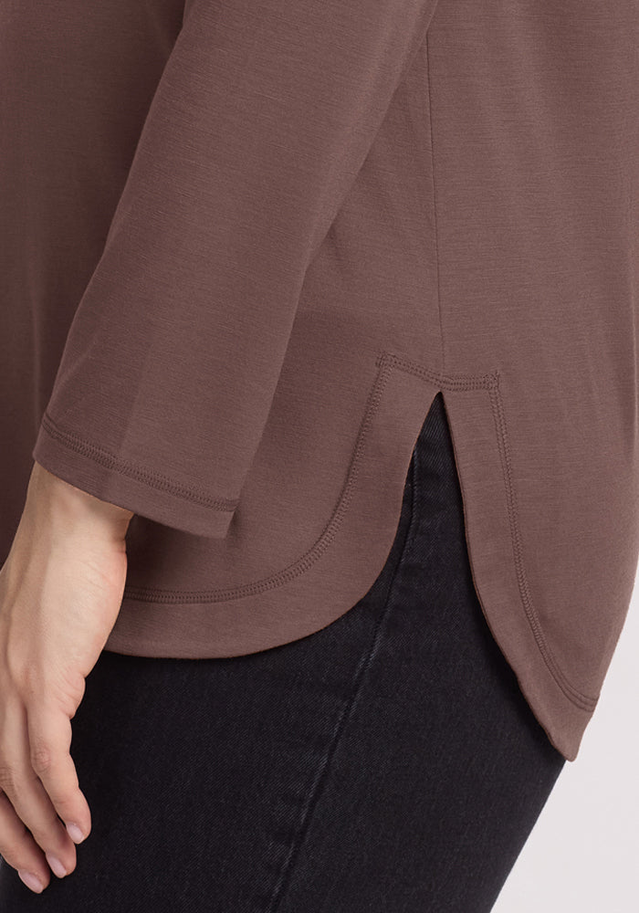 A person in the Woolx Hazel Tunic in Peppercorn with black pants, shown from the hip down.