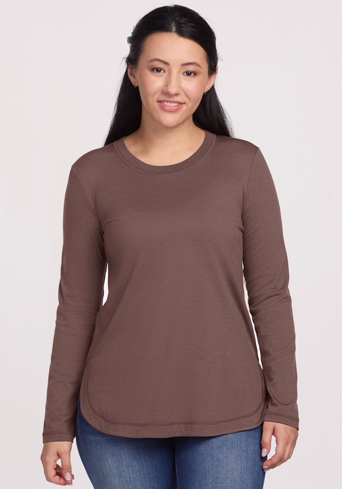 A woman wears the Woolx Hazel Tunic in Peppercorn with blue jeans, standing forward and smiling slightly. | Sarah is 5'8", wearing a size S
