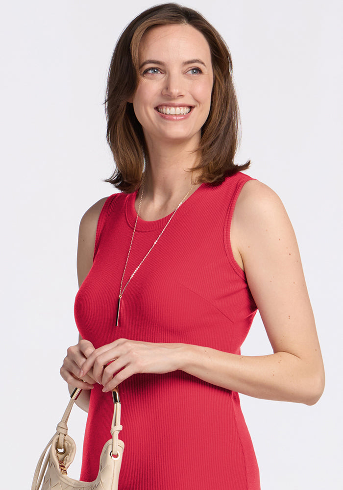 Woman wearing the Woolx Iris Ribbed Dress in Berry Ice Pop, smiling with a beige handbag and long necklace.