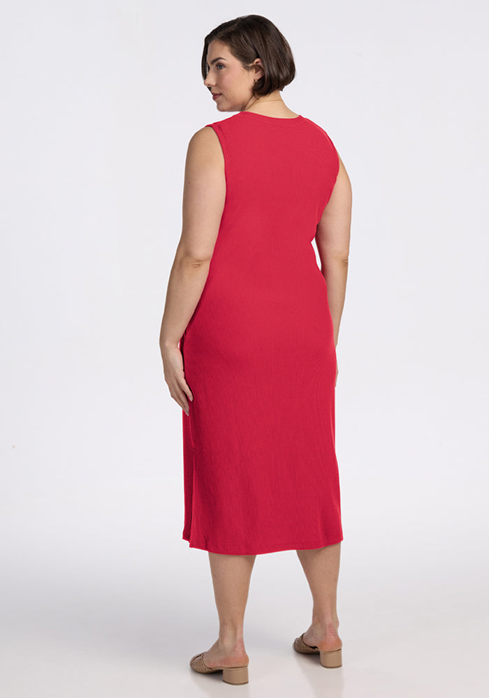 A woman wears the Woolx Iris Ribbed Dress in Berry Ice Pop, standing with her back to a plain white background.
