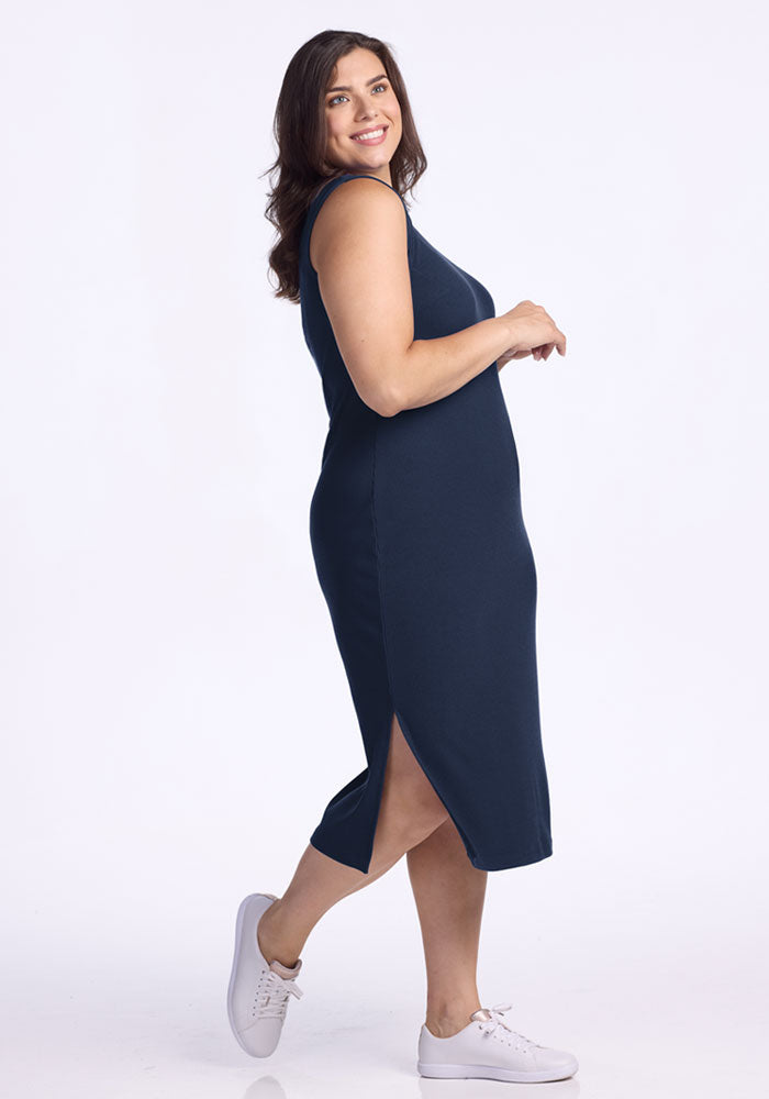 Woman in the Woolx Iris Ribbed Dress in Deep Navy, standing sideways against a white background. Final Sale.