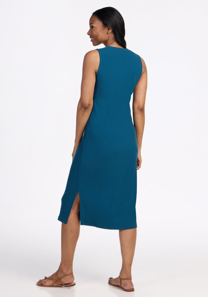 Woman in the Woolx Iris Ribbed Dress in Moroccan Blue, sleeveless with side slit, seen from behind, wearing sandals.