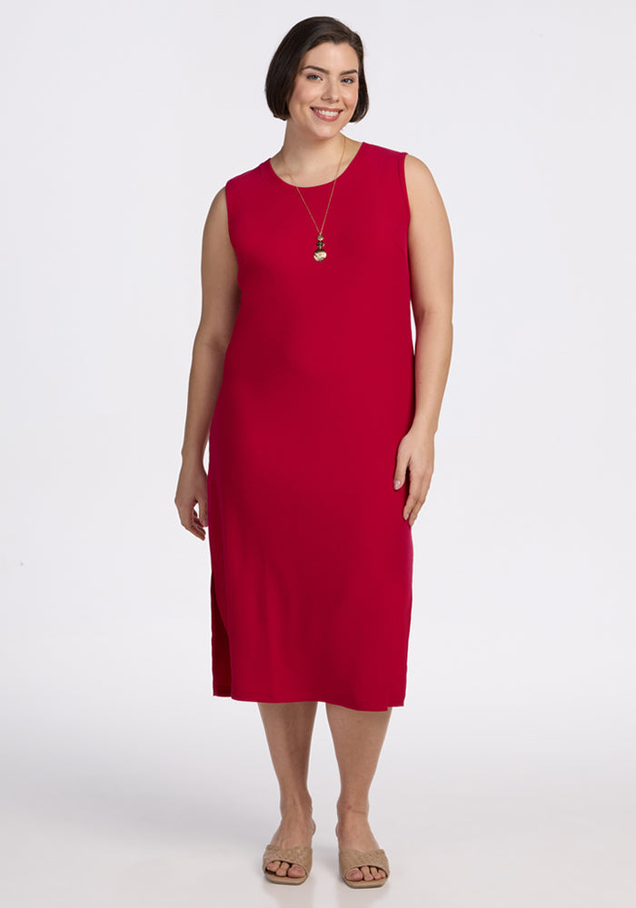 Woman in Woolx Iris Ribbed Dress in Poppy Spark, smiling against a white background. Final Sale.