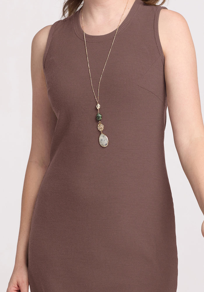 Woman in the Woolx Iris Ribbed Dress in Peppercorn and a long stone pendant, shown shoulders to mid-thigh.