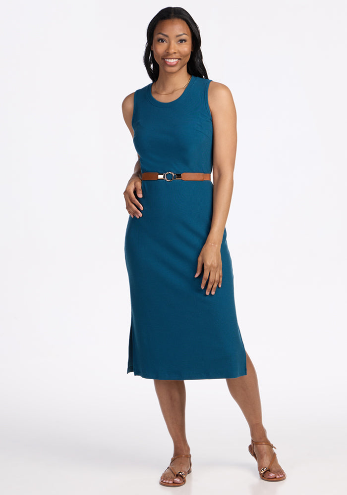 Woman in a Woolx Iris Ribbed Dress in Moroccan Blue, standing and smiling against a plain white background.