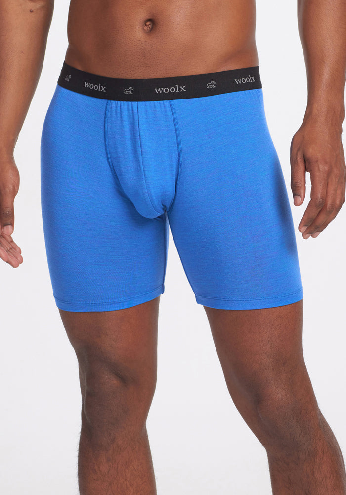 A person models Woolx Jazzy No Fly Boxer Briefs in Blue Gelato, featuring a black "woolx" waistband, against a plain white background. Only the torso and upper legs are visible.