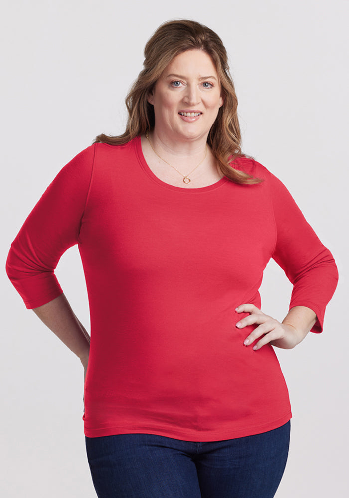 A woman smiles in the Woolx Jenny 3/4 Sleeve Crew Neck - Berry Ice Pop, with jeans against a plain background. | Cambre is 5'11", wearing a size XL