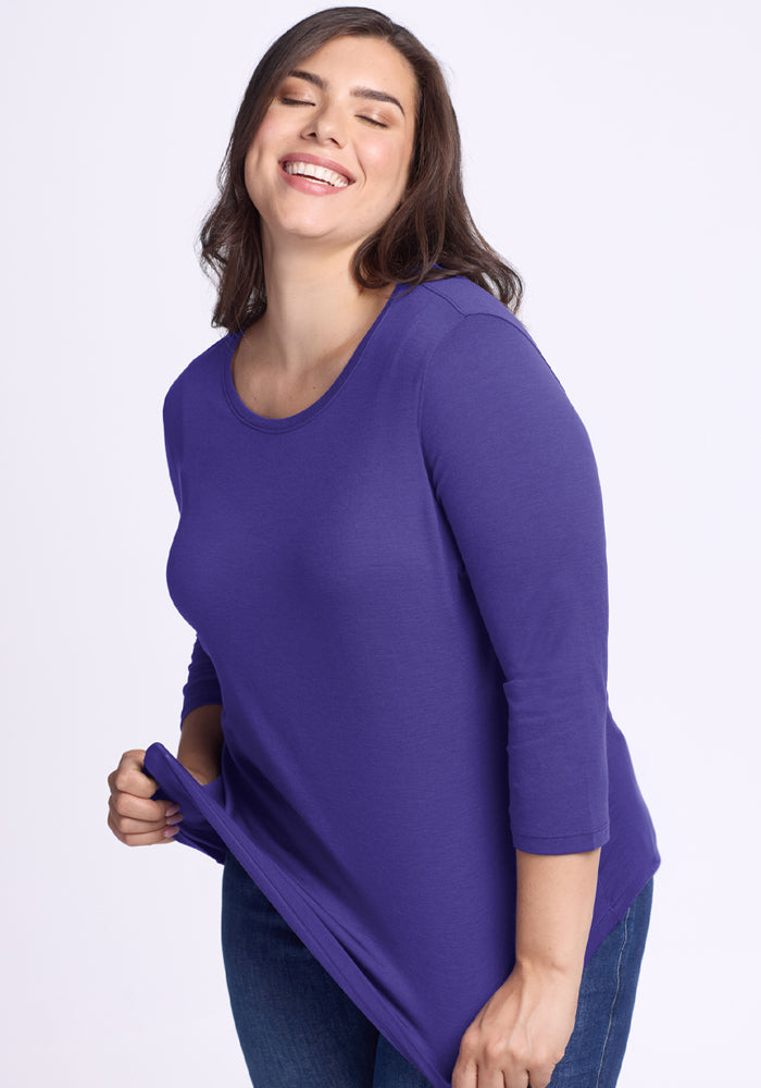 A smiling woman wears the Woolx Jenny 3/4 Sleeve Crew Neck in Berry Indigo with jeans against a light background.