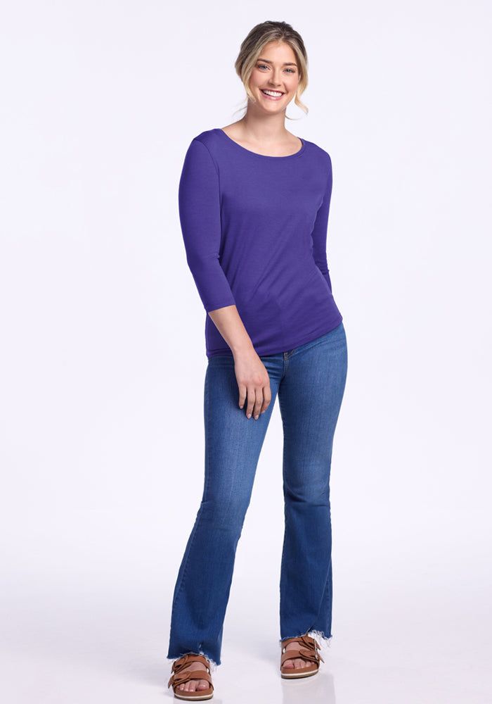 Smiling woman in Woolx Jenny 3/4 Sleeve Crew Neck - Berry Indigo and blue jeans, against a white background.