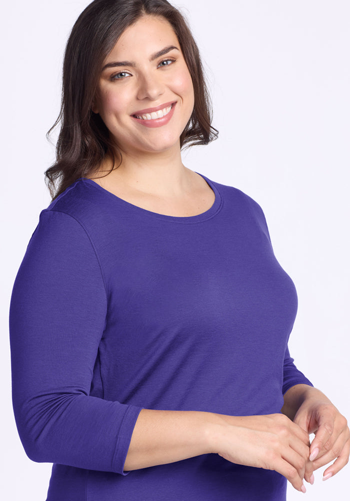 Woman smiling in a Woolx Jenny 3/4 Sleeve Crew Neck - Berry Indigo, standing against a plain light background.