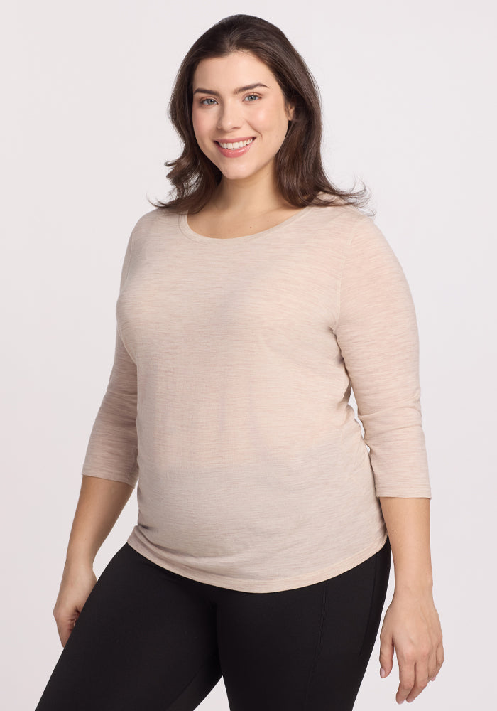 A smiling person with long dark hair stands against a neutral background, wearing Woolx's Jenny 3/4 Sleeve Crew Neck in Cream Heather with black pants. | Juliana is 5'10", wearing a size XL
