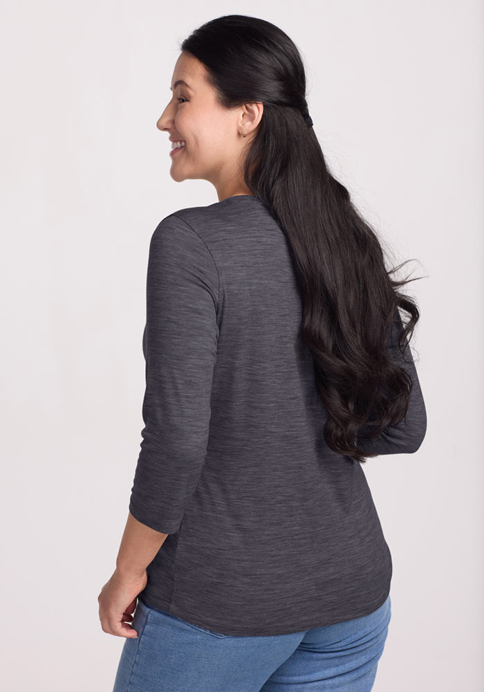 Woman with long dark hair in a Woolx Jenny 3/4 Sleeve Crew Neck in Cinder Melange, smiling and looking to the side.