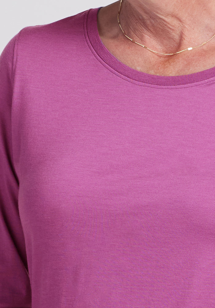 A person wears the Woolx Jenny 3/4 Sleeve Crew Neck in Purple Wine with a thin gold necklace, neck to upper chest shown.