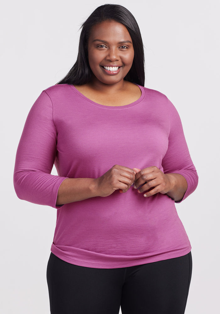 Smiling woman wears Woolx Jenny 3/4 Sleeve Crew Neck in Purple Wine and black pants against a light background.