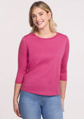 Woman in Woolx Jenny 3/4 Sleeve Crew Neck in Raspberry Fizz and blue jeans against a light background.
