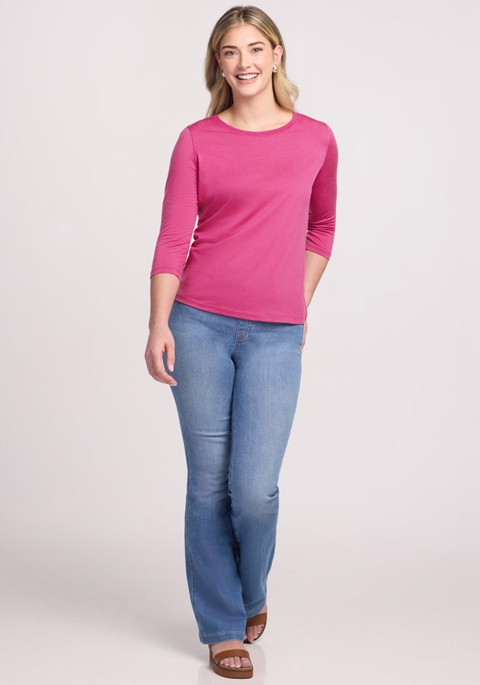 Woman wearing the Woolx Jenny 3/4 Sleeve Crew Neck in Raspberry Fizz, smiling in blue jeans against a light backdrop.