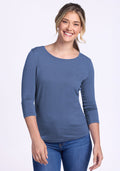 Smiling woman in a Woolx Jenny 3/4 Sleeve Crew Neck – Skyline, paired with blue jeans, against a plain background.