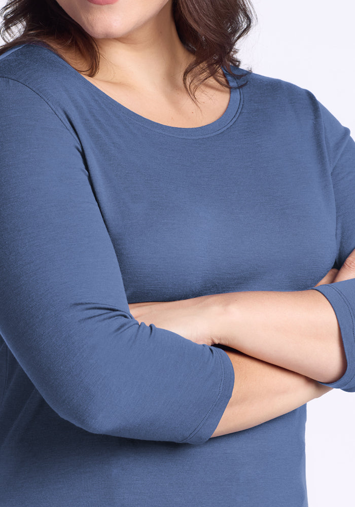 Woman in a blue Woolx Jenny 3/4 Sleeve Crew Neck, arms crossed, shown shoulders to waist on a light background.