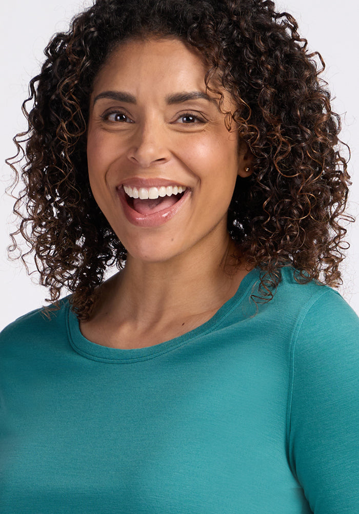 Smiling woman in Woolx Jenny 3/4 Sleeve Crew Neck in Surfside, facing forward against a light background.
