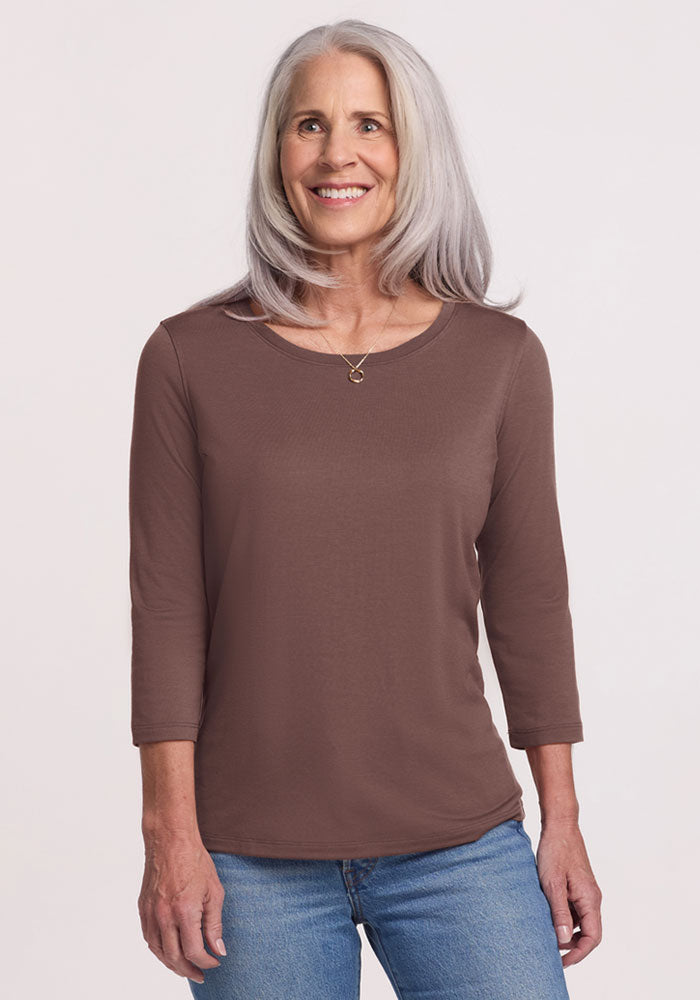 Smiling older woman wearing the Woolx Jenny 3/4 Sleeve Crew Neck in Peppercorn and blue jeans against a light background.