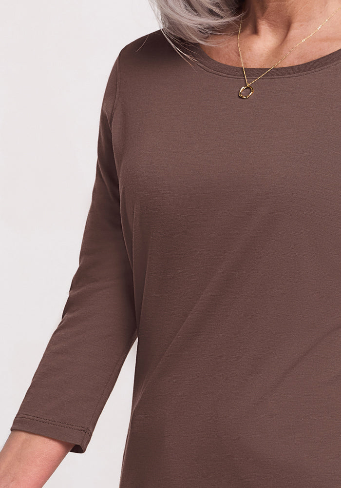A woman wearing the Woolx Jenny 3/4 Sleeve Crew Neck in Peppercorn and a gold necklace with a circular pendant.