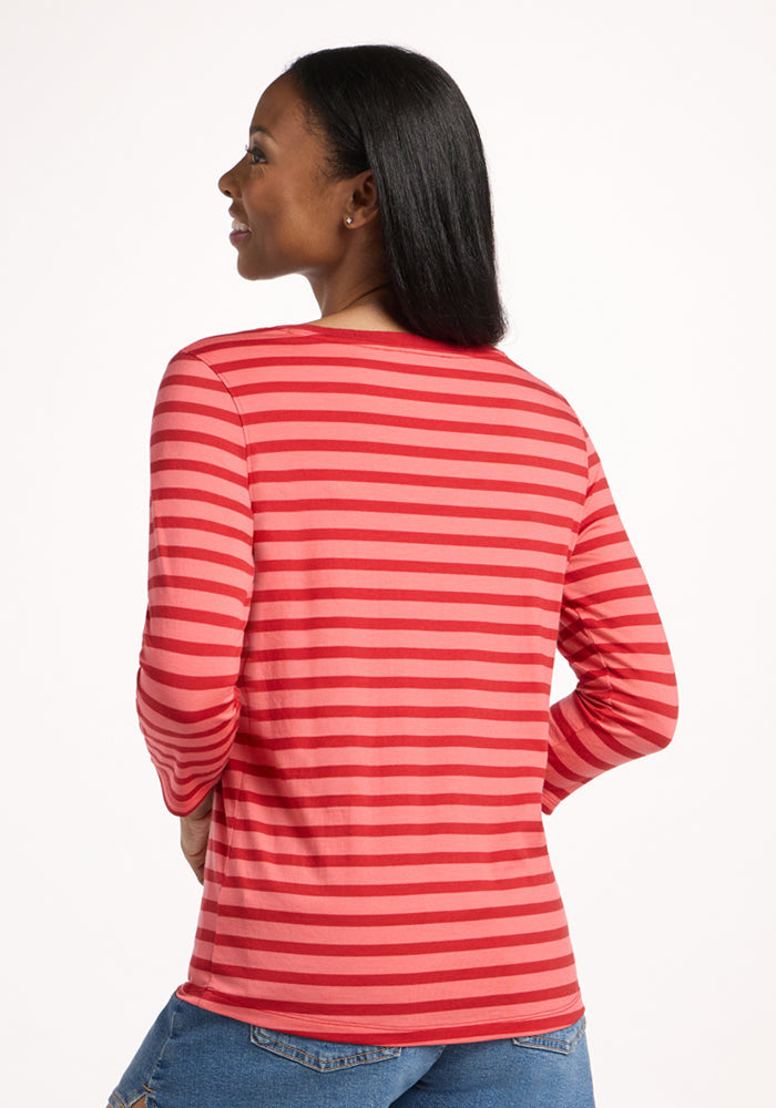 A woman with long dark hair faces away, wearing the Woolx Jenny 3/4 Sleeve Crew Neck in Wildberry Stripe and blue jeans, against a plain white background.