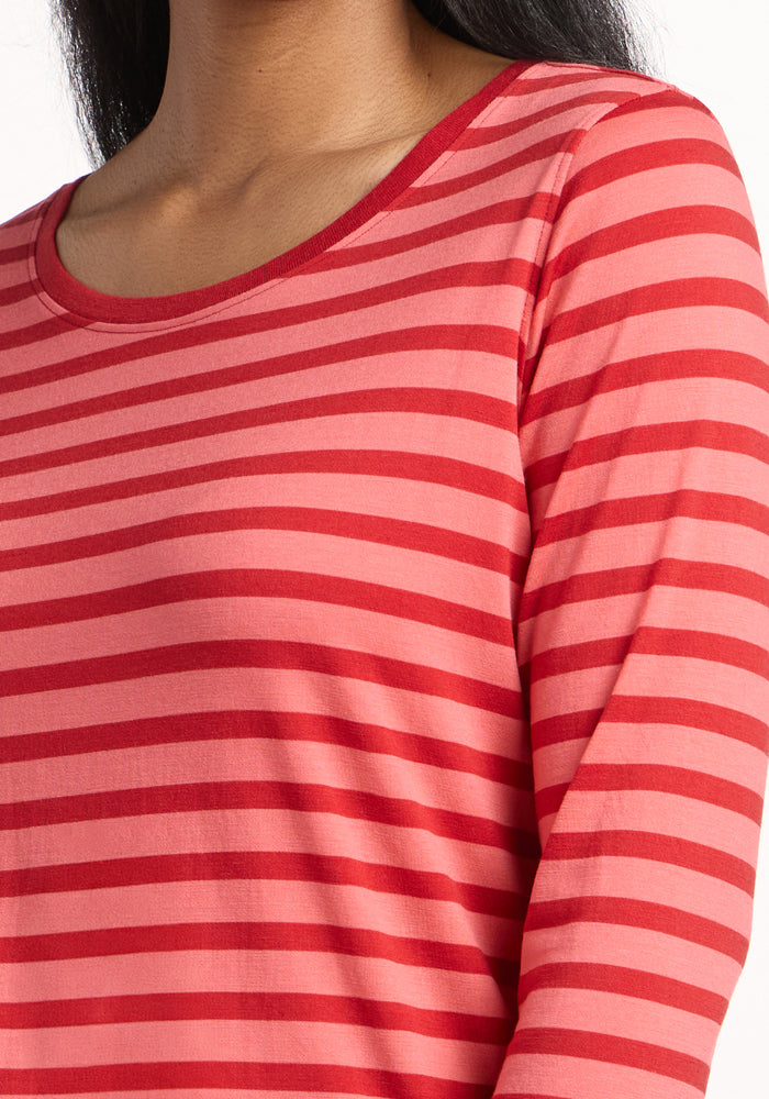 A person wears the Woolx Jenny 3/4 Sleeve Crew Neck in Wildberry Stripe—red and pink horizontal stripes. The image is cropped to show only the upper torso and part of the neck; the face is not visible.