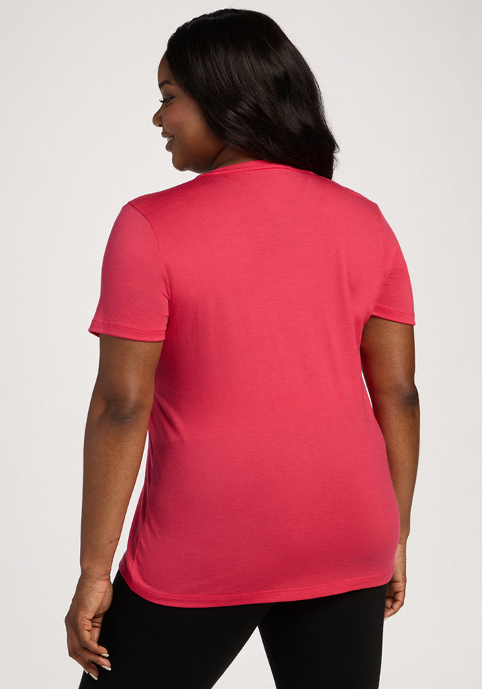 Woman with long dark hair in the Woolx Junie V Neck - Berry Ice Pop, relaxed fit tee, and black pants, facing away.