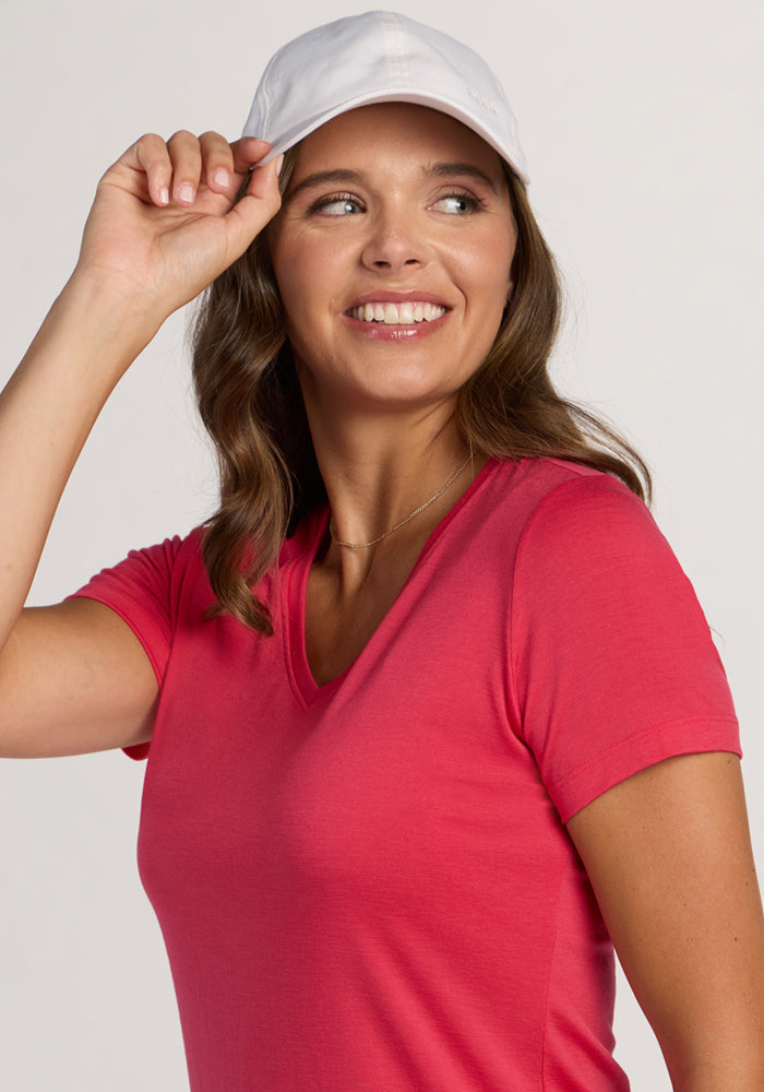 Smiling woman in Woolx Junie V Neck - Berry Ice Pop tee, looking to the side against a light background.