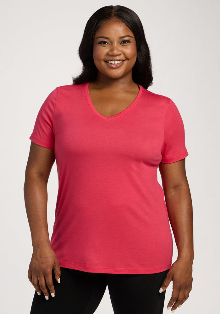 Woman smiling in the Woolx Junie V Neck - Berry Ice Pop tee and black pants, standing against a plain background. | Sapphire is 5’8”, wearing a size XL