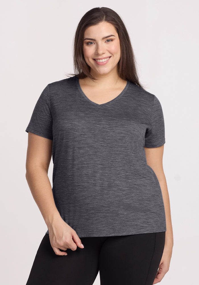 Smiling woman in a Woolx Junie V Neck tee in Cinder Melange and black pants, with long brown hair.